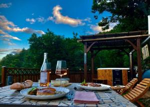 a table with food and a glass of wine at Domaine l'Esquiròu - L'insolite TAMIA in Asperjoc