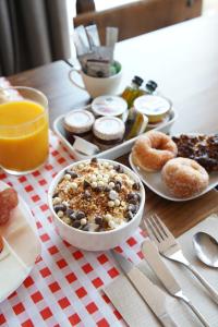 a table topped with plates of breakfast foods and orange juice at HOTEL POSADA LaS RETAJAS in Medinaceli