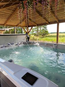 a hot tub with water coming out of it at FINN VILLAGE "Mountain View Cottage" Private Garden, 9-seater Hot Tub, Firepit & Pizza Stove in Drymen