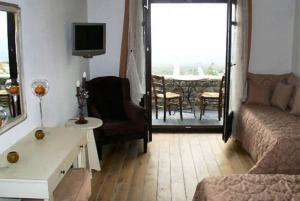 - un salon avec un canapé, une table et une télévision dans l'établissement Nastou View Hotel, à Ano Poroia