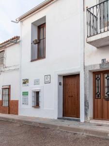 un edificio blanco con puertas de madera en una calle en Casa Rural El Palomeque, 