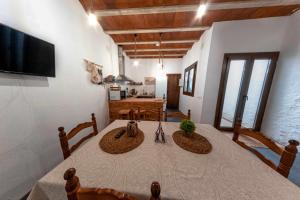 a dining room with a table and a television at Casa Rural El Palomeque 