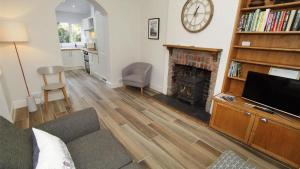a living room with a television and a fireplace at Oakland Road, Mumbles in The Mumbles