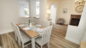 a dining room with a table and chairs and a fireplace at Oakland Road, Mumbles in The Mumbles
