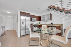 a kitchen with a glass table and white appliances at Stunning 1 Bedroom Loft in The Heart of Brickell in Miami