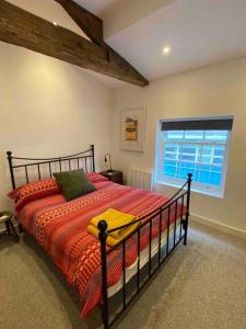 a bedroom with a bed with a red blanket and a window at Stylish 3 bedroom apartment in historic city centre building in Sheffield