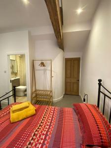 a bedroom with a red bed with a yellow towel on it at Stylish 3 bedroom apartment in historic city centre building in Sheffield