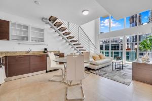 a kitchen and living room with a spiral staircase at Stunning 1 Bedroom Loft in The Heart of Brickell in Miami
