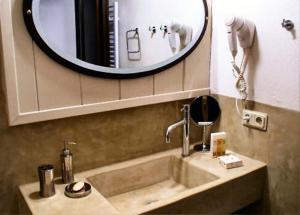 een wastafel in de badkamer met een grote spiegel erboven bij Nastou View Hotel in Áno Poróïa +15 foto's