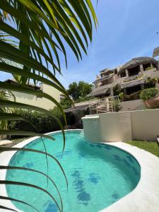 a swimming pool in front of a house at Agua Azul la Villa in Santa Cruz Huatulco