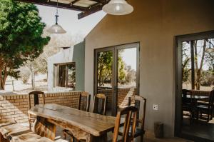 a wooden table and chairs on a patio at Wilgeboomsdrift Safaris in Modimolle