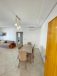 a dining room with a table and chairs and a couch at Appartement avec piscine taghazout imi Ouaddar in Agadir nʼ Aït Sa