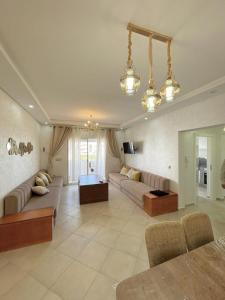 een grote woonkamer met 2 banken en een tafel bij Appartement avec piscine taghazout imi Ouaddar in Agadir nʼ Aït Sa
