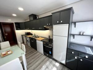 a kitchen with black cabinets and a white refrigerator at Alojamiento Las Maguillas in Ezcaray +9 photos