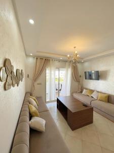 een woonkamer met een bank en een tafel bij Appartement avec piscine taghazout imi Ouaddar in Agadir nʼ Aït Sa