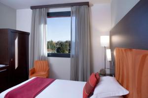 a bedroom with a bed and a window at Dolce by Wyndham Milan Malpensa in Somma Lombardo