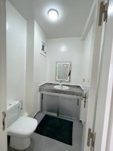 y baño con aseo blanco y lavamanos. en Appartement avec piscine taghazout imi Ouaddar en Agadir nʼ Aït Sa
