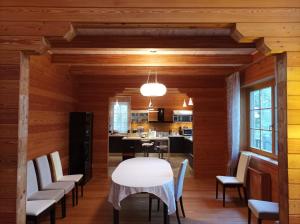 a dining room with a white table and chairs at Jaunakmeņi in Priežmale