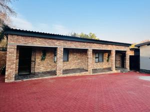 a brick building with windows and a red brick driveway at 6 the Curve Unit 12 in Johannesburg