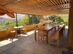 una gran mesa de madera y sillas en un patio en Cabalgatas y Alojamiento LocuraChile, en Hurtado