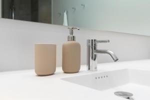 a bathroom sink with two soap bottles next to a faucet at Come Stay Close To Nyhavn - CPH's Best View in Copenhagen