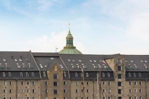 a large building with a tower on top of it at Come Stay Close To Nyhavn - CPH's Best View in Copenhagen