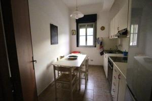 una pequeña cocina con mesa y sillas. en Casa vite, en Forza dʼAgro