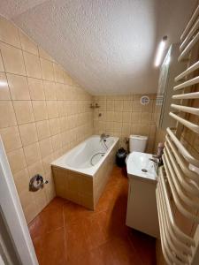 a bathroom with a tub and a toilet and a sink at Domek na Mazurach niedaleko jeziora in Pisz