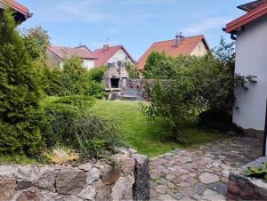 a yard of a house with a stone walkway at Domek na Mazurach niedaleko jeziora in Pisz