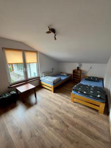 pokój z dwoma łóżkami i stołem w obiekcie Domek na Mazurach niedaleko jeziora w Piszu