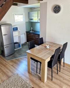 eine Küche und ein Esszimmer mit einem Holztisch und Stühlen in der Unterkunft Villa Felícia in Balatonszepezd