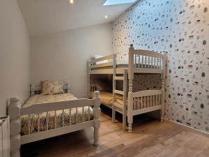 a bedroom with two bunk beds and a wall with fish wallpaper at Maison Poitevine 9/10 personnes in Chaunay