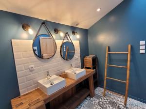 a bathroom with two sinks and two mirrors at Maison Poitevine 9/10 personnes in Chaunay +12 photos