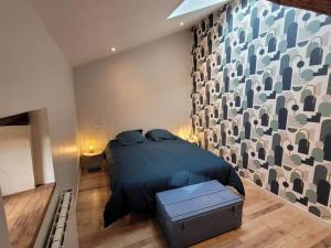 sypialnia z łóżkiem i dużą ścianą w obiekcie Maison Poitevine 9/10 personnes w mieście Chaunay