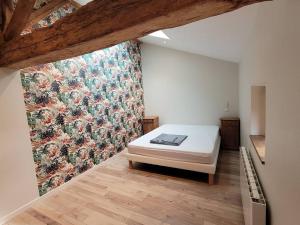a bedroom with a bed and a floral wall at Maison Poitevine 9/10 personnes in Chaunay