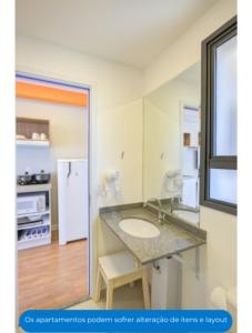 a bathroom with a sink and a refrigerator at Roomo OY Frei Caneca Residencial in São Paulo