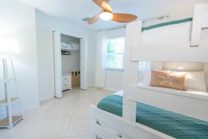 a bedroom with a bunk bed and a ceiling fan at Secluded Beachfront Vibes - Surf & Pet Friendly in Fort Pierce