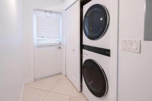 a white laundry room with a washer and dryer at Secluded Beachfront Vibes - Surf & Pet Friendly in Fort Pierce