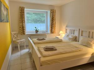 2 camas en un dormitorio con ventana en Kastanienhof Holländer, en Schlotfeld