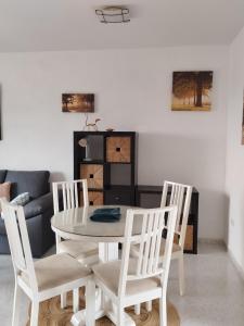 een eetkamer met een witte tafel en 4 stoelen bij Casa Cariño in Torrox