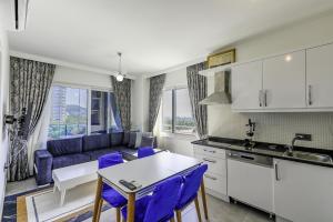 cocina y sala de estar con sofá y mesa en Residence w Balcony and Shared Pool 7 min to Coast en Mahmutlar