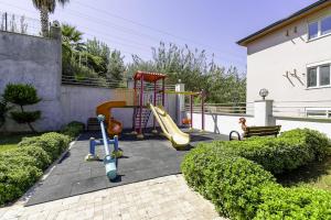 um parque infantil com um escorrega e um baloiço em Residence w Balcony and Shared Pool 7 min to Coast em Mahmutlar