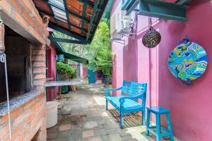 een blauwe bank buiten een roze gebouw bij Ibirapuera Park House in Sao Paulo