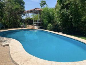 une grande piscine bleue avec un kiosque dans l'établissement Brisas el Valle, à Temixco