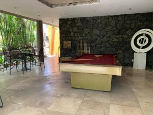 a pool table in a room with a stone wall at Brisas el Valle in Temixco