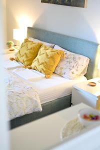 un lit avec des oreillers jaunes et une tête de lit bleue dans l'établissement Studio Apartman Iva, à Subotica