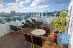 un balcone con sedie e un tavolo su un edificio di Studio a 150m da praia de Piatã a Salvador