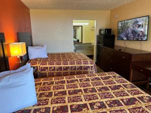 Habitación de hotel con 2 camas y TV de pantalla plana. en Country Hearth Inn & Suites Cartersville, en Cartersville