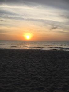 a sunset on a beach with the ocean at Carl and Veronica Guest House in Sanyang