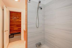 ein Bad mit einer Dusche und einem Waschbecken in der Unterkunft The Great Escape–2 Bdrm w/Private Sauna in Village in Big White